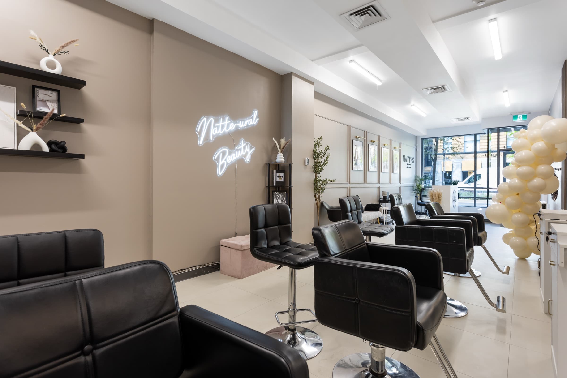 The salon floor and the Natt-u-ral Beauty neon sign at Nattes Hair Studio
